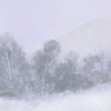 A silent winter mountain shrouded in snowy mist.